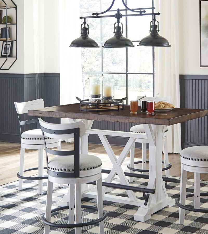 a high-top table with white chairs, a black and white checkered rug, and food on the table